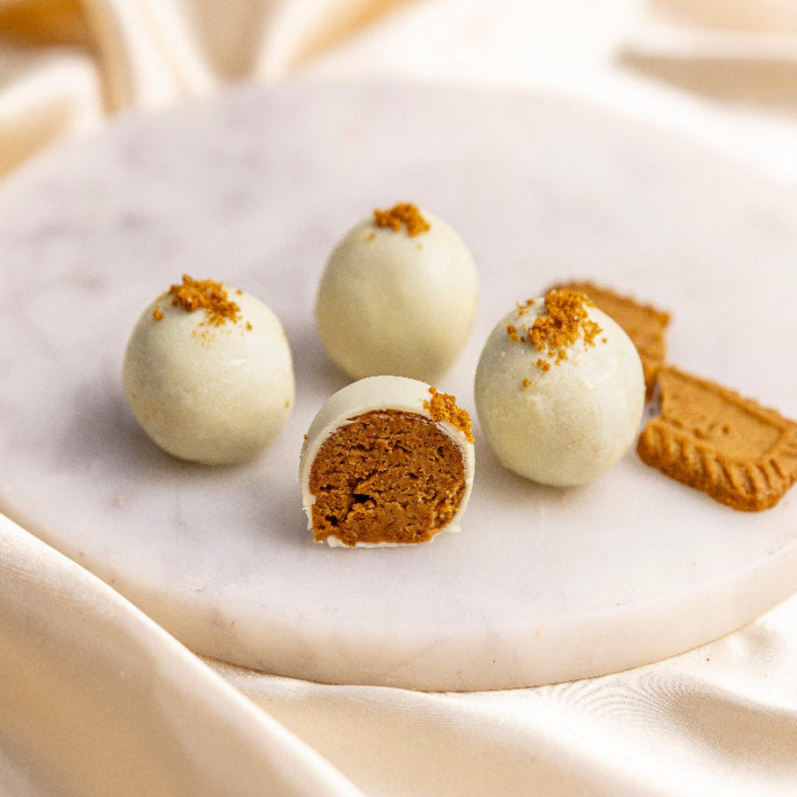 White chocolate truffles with cookie pieces on a marble surface